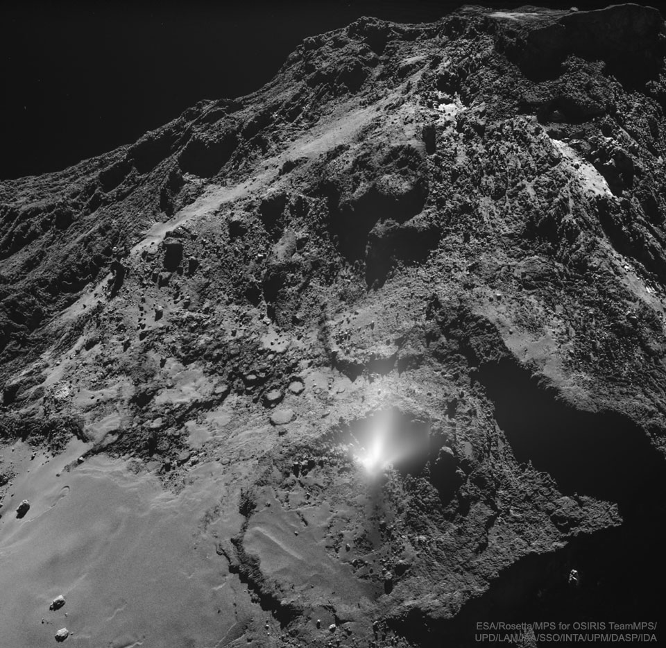 A dark and jagged hill is shown strewn with rocks.
On the slope is a white foggy area that appears to 
emanate from a non-descript place on the rock face.
Please see the explanation for more detailed information.