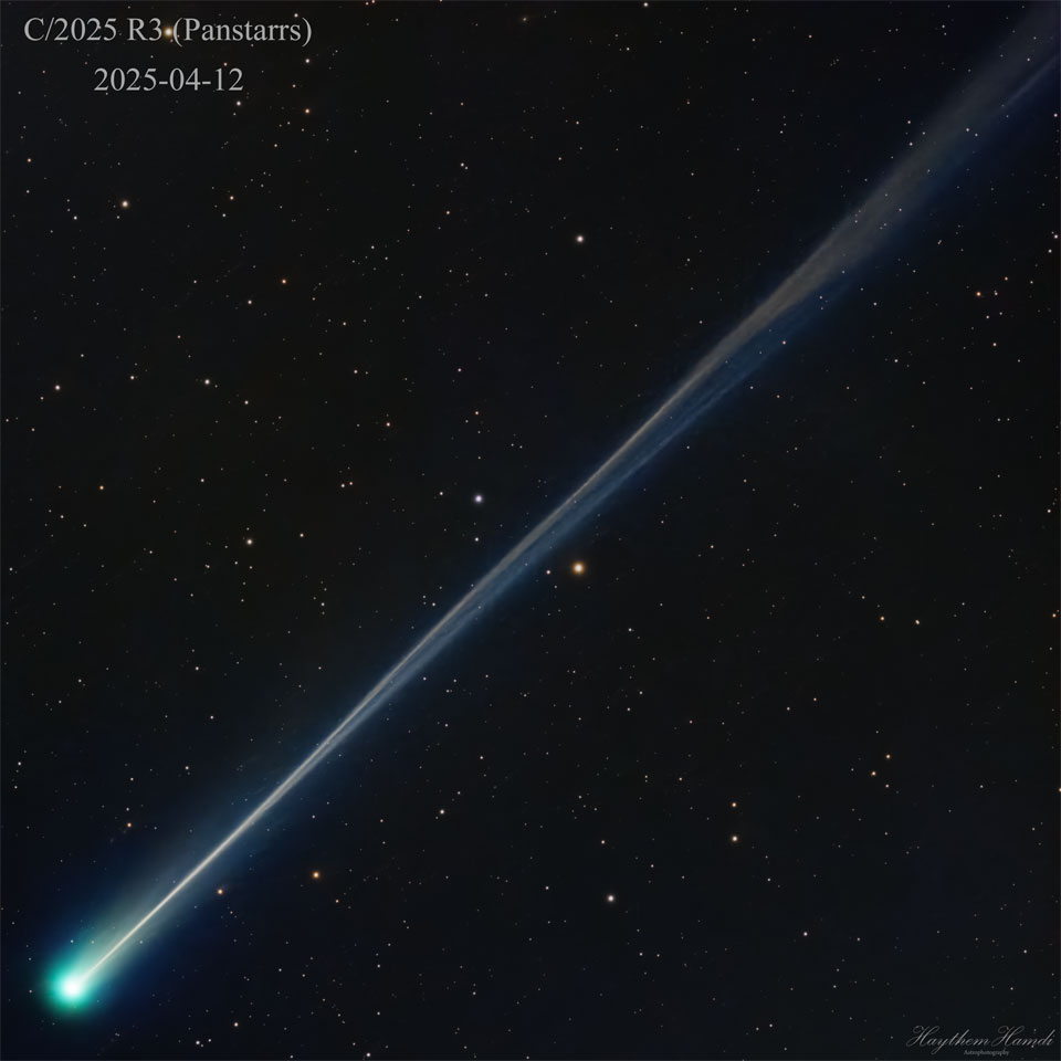 A star field surrounds a bright comet with a long
tail. The green coma of the comet is seen on the lower left,
while the light blue ion tail extends to the upper right
and shows wavey structure. 
Please see the explanation for more detailed information.