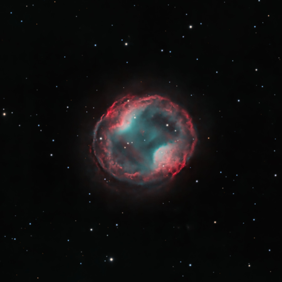 A bubble of gas occupies the center of the image with a few stars in the fore- and background. On opposite sides of the bubble, there are two 
regions where the gas pinches inward. This makes the inner region of the nebula appear like a peanut inside a larger ring.