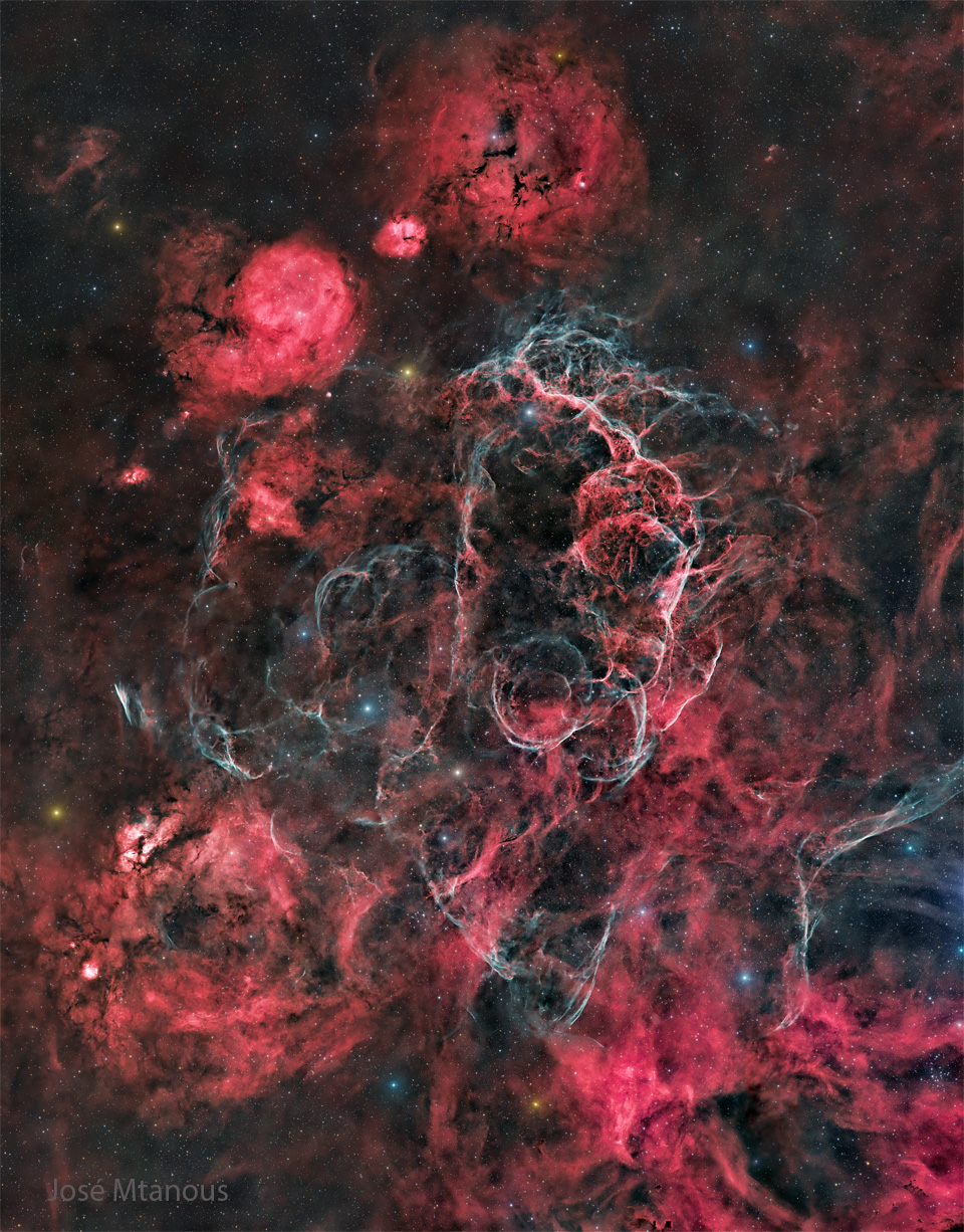 The starfield is filled with many red nebulas, areas
of dark dust, and light blue filaments. 
Please see the explanation for more detailed information.